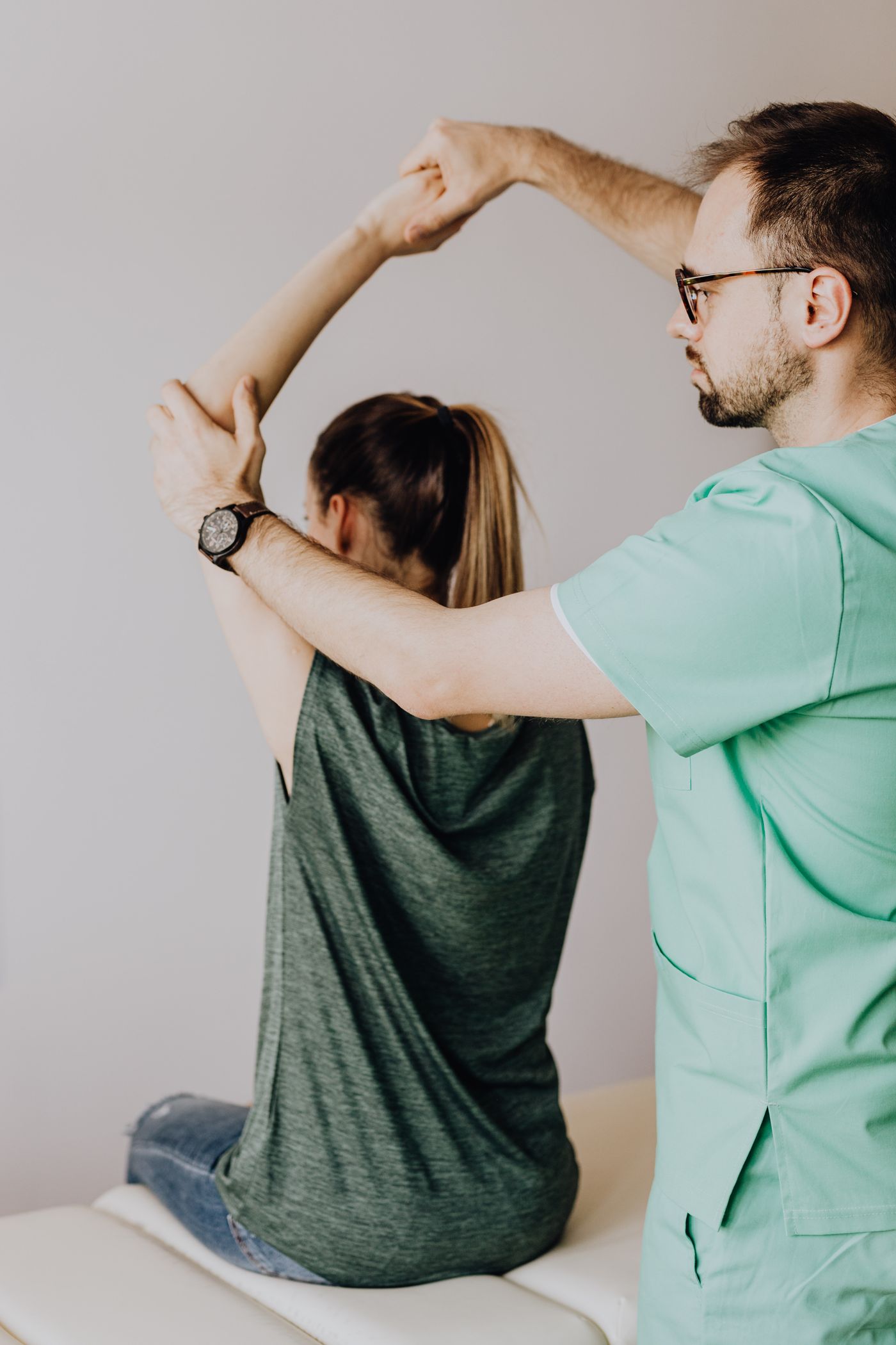 Physiotherapist moving a patient's shoulder through its range of motion