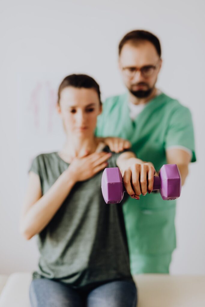 Physiotherapist guiding a patient through a dumbbell exercise in Ottawa