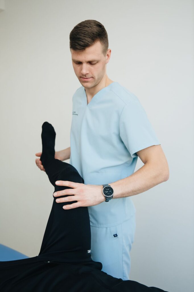 Physiotherapist assessing a patient's hip and leg movement in Ottawa